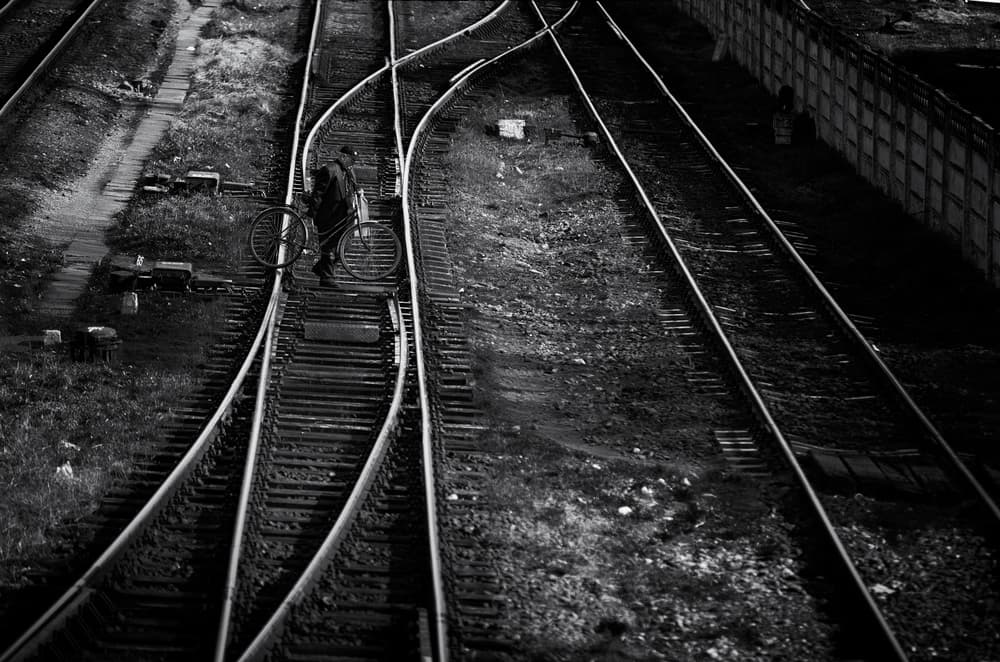 Man and Bike on Tracks by Julien Oncete — canvas wall art