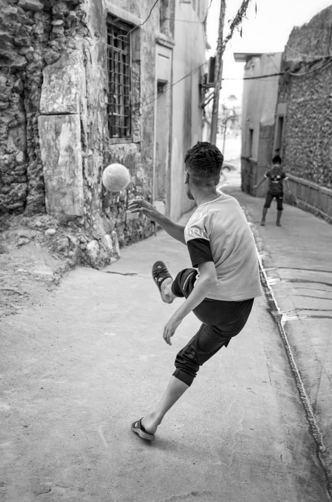 Boy Playing Street Soccer by Bashar Alsofey — canvas wall art