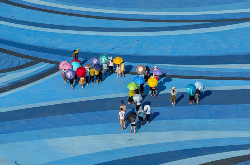 Colorful Umbrellas Blue Waves by Karim Al Thahaby — canvas wall art