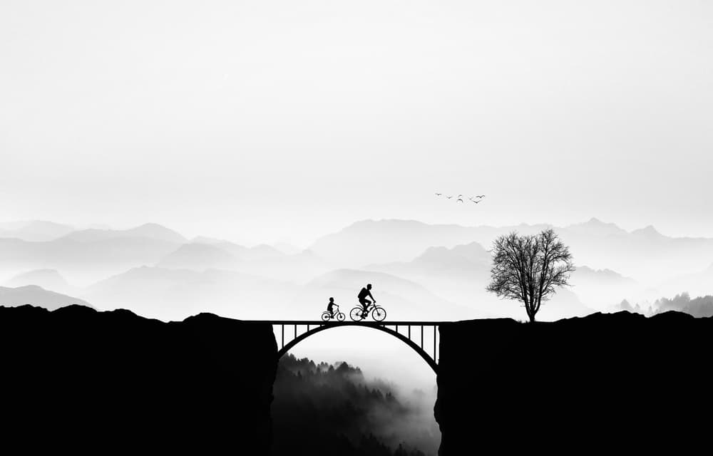 Cyclists on a Misty Bridge by Bess Hamiti — canvas wall art