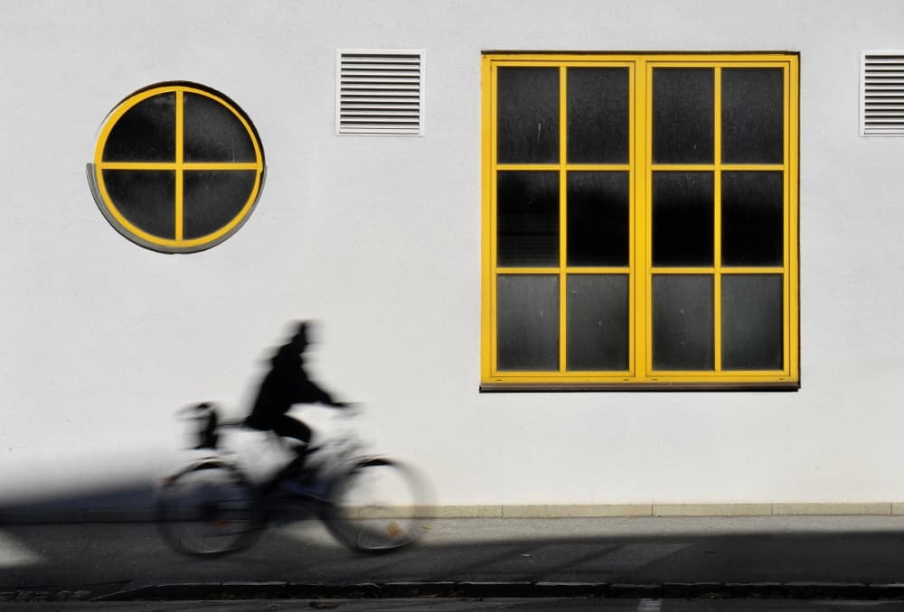 Cyclist Passing Yellow Windows by Darko Cuder — canvas wall art