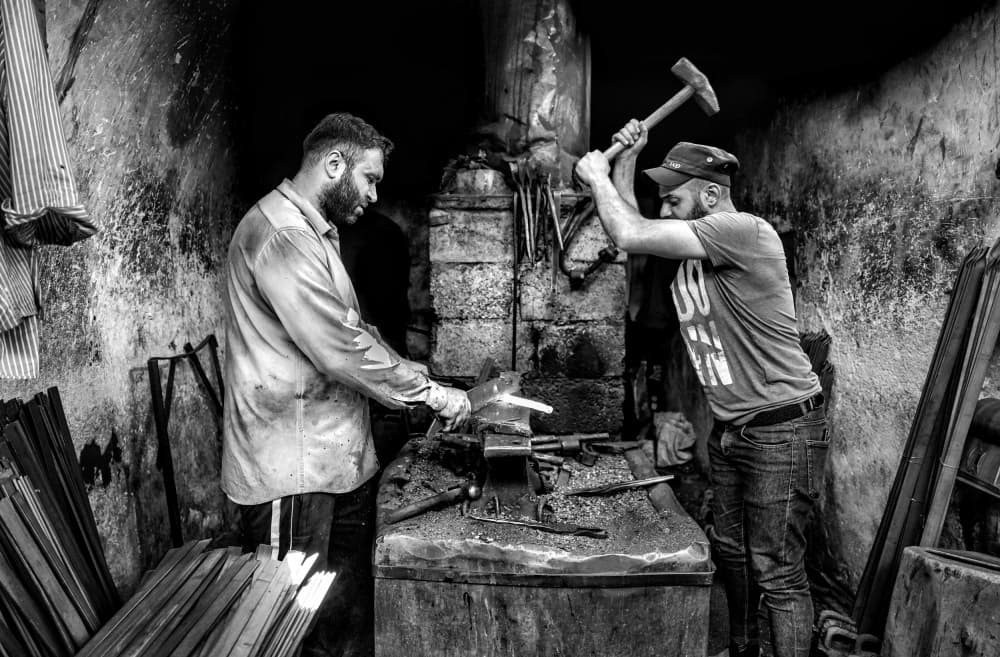 Blacksmiths Forging Metal by Bashar Alsofey — canvas wall art