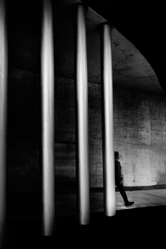 Man Through Concrete Pillars by Antonio Grambone — canvas wall art