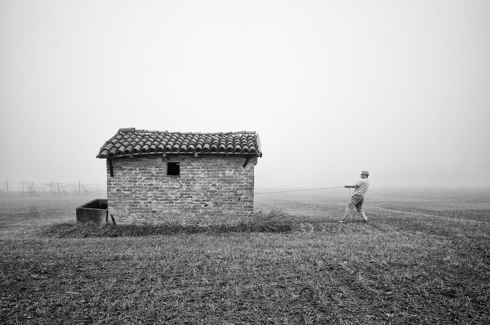 Man Pulling Rustic Building by Carlo Ferrara — canvas wall art