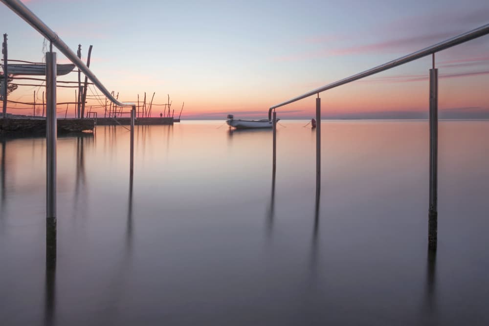 Serene Sunset Boat by Emanuela Sol — canvas wall art