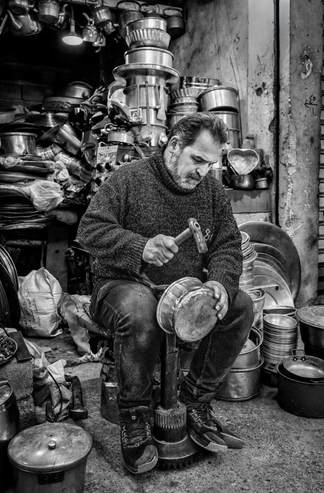 Artisan Hammering Metal Pot by Bashar Alsofey — canvas wall art