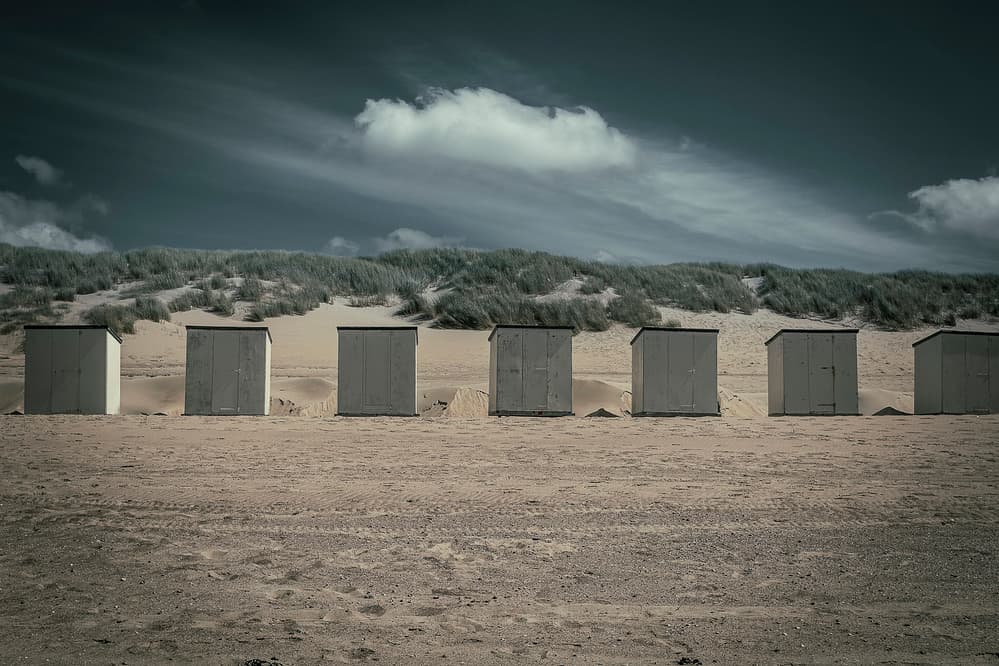 Moody Coastal Huts by Bernardine de Laat — canvas wall art