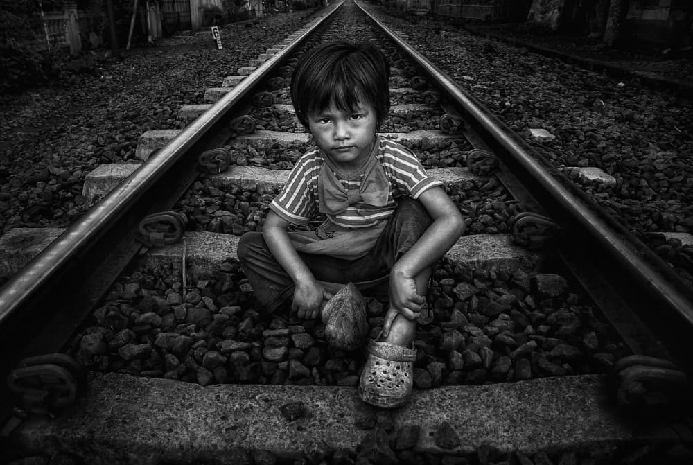 Pensive Child on Tracks by Firman Maulana — canvas wall art