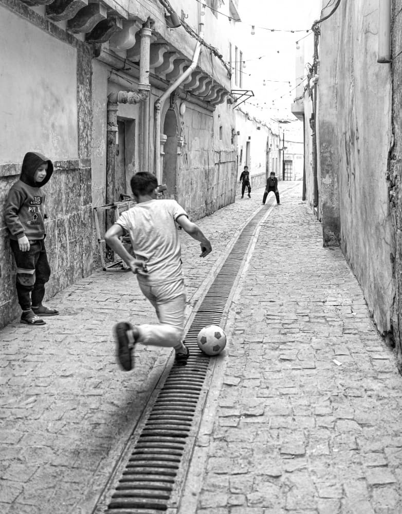 Boys Playing Street Soccer by Bashar Alsofey — canvas wall art