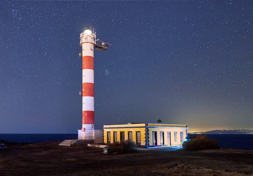 Starry Night Lighthouse by JUAN CARLOS HERVÁS MARTÍNEZ — canvas wall art