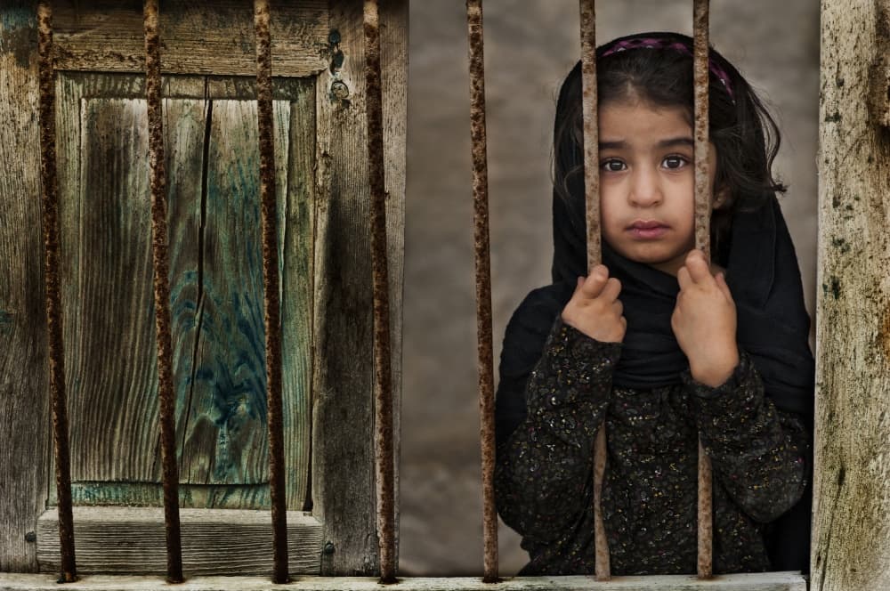 Solemn Girl Through Bars by Saeed Dhahi — canvas wall art