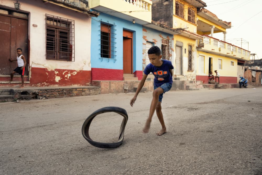 Boy Rolling Tire by Jurij Bizjak — canvas wall art