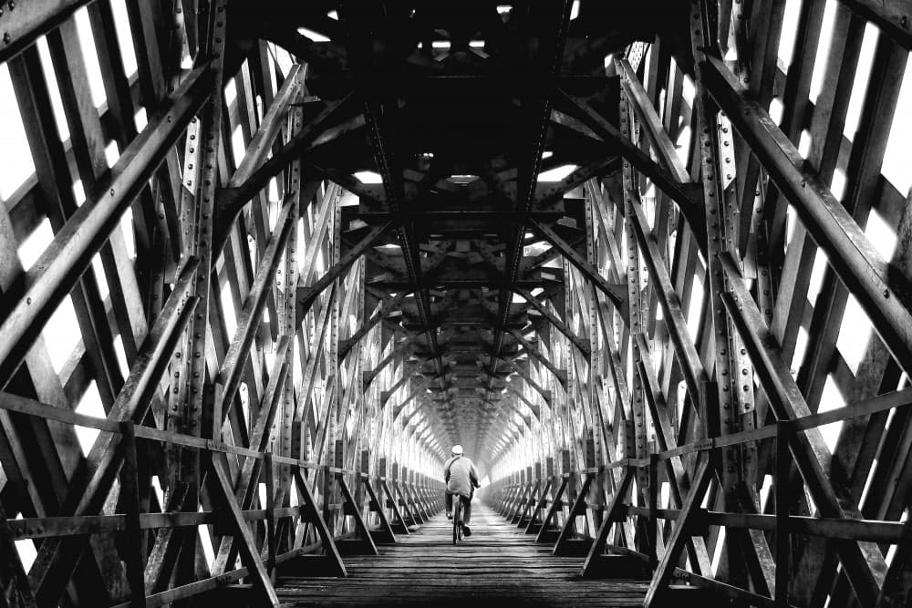 Covered Bridge Cyclist by Firman Maulana — canvas wall art