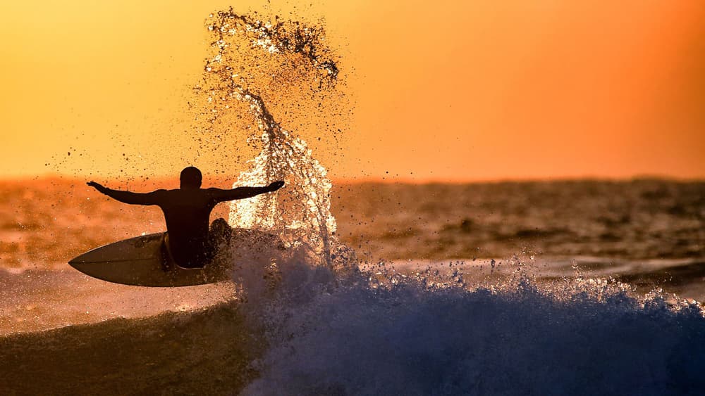Surfer Rides Sunset Wave by Eyal Bussiba — canvas wall art