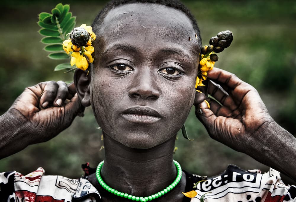 African Child with Yellow Flowers by Joxe Inazio Kuesta Garmendia — canvas wall art