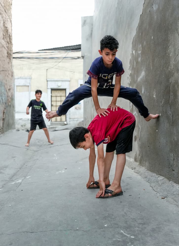 Boys Playing Leapfrog by Bashar Alsofey — canvas wall art