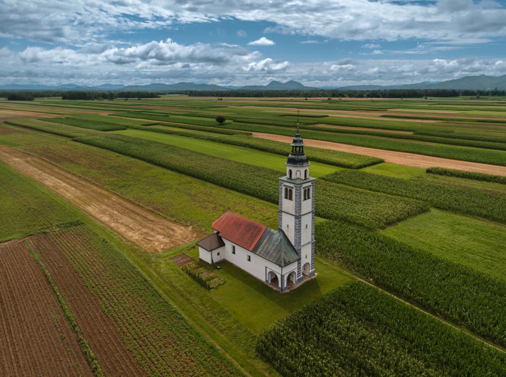 Country Church Among Fields by Jure Kravanja — canvas wall art