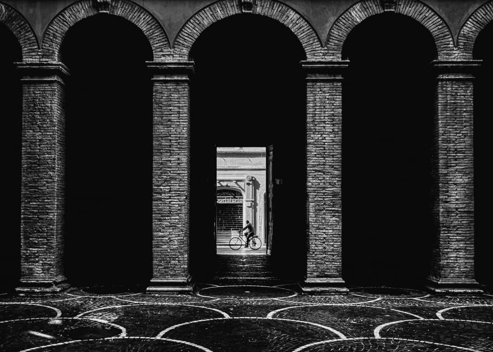 Cyclist Through City Arches by Valentin Borsan — canvas wall art