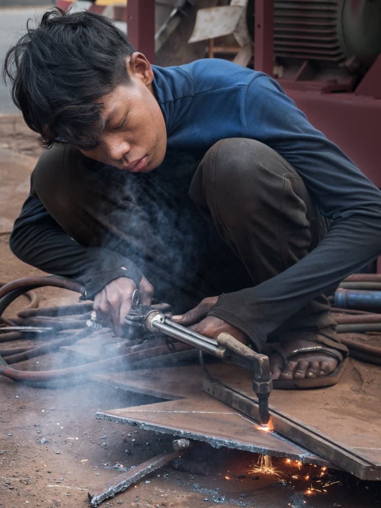 Focused Worker Cutting Steel by Patrick Dessureault — canvas wall art