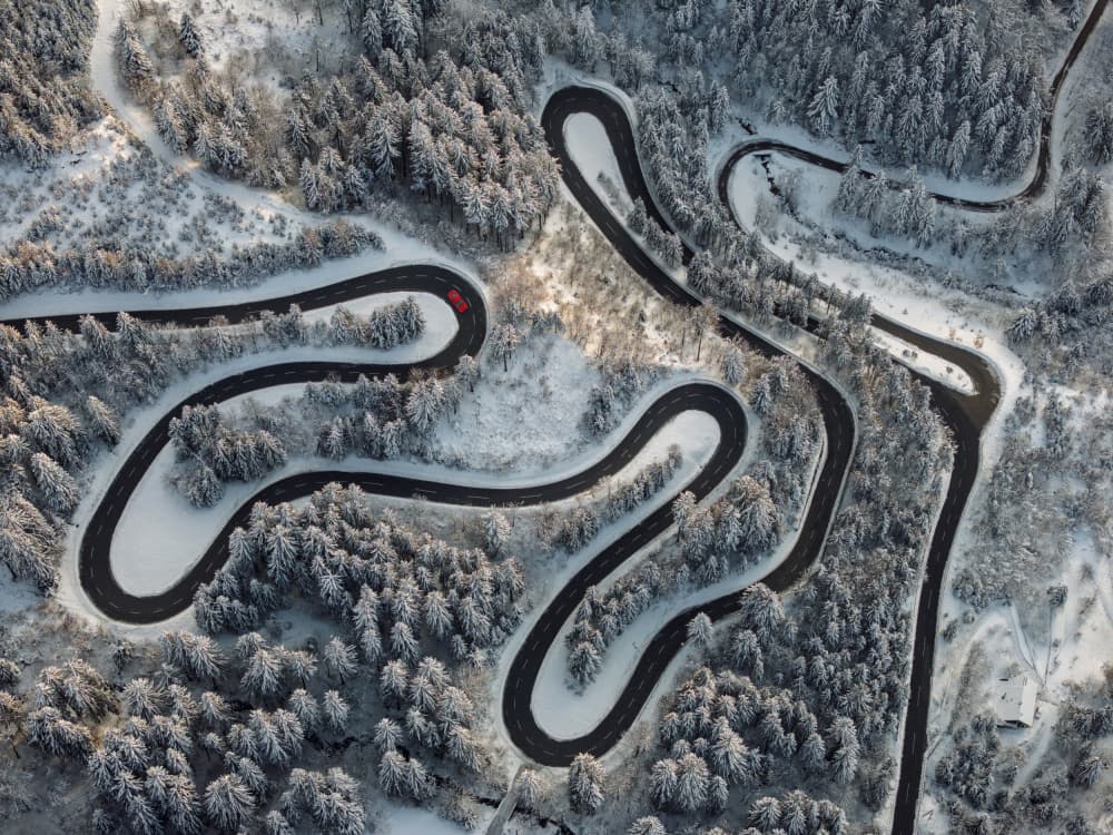 Red Car Snowy Mountain Road by Jure Kravanja — canvas wall art