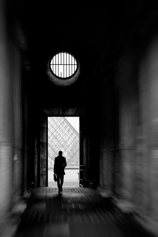 Man Approaches Louvre Pyramid by Eric Drigny — canvas wall art