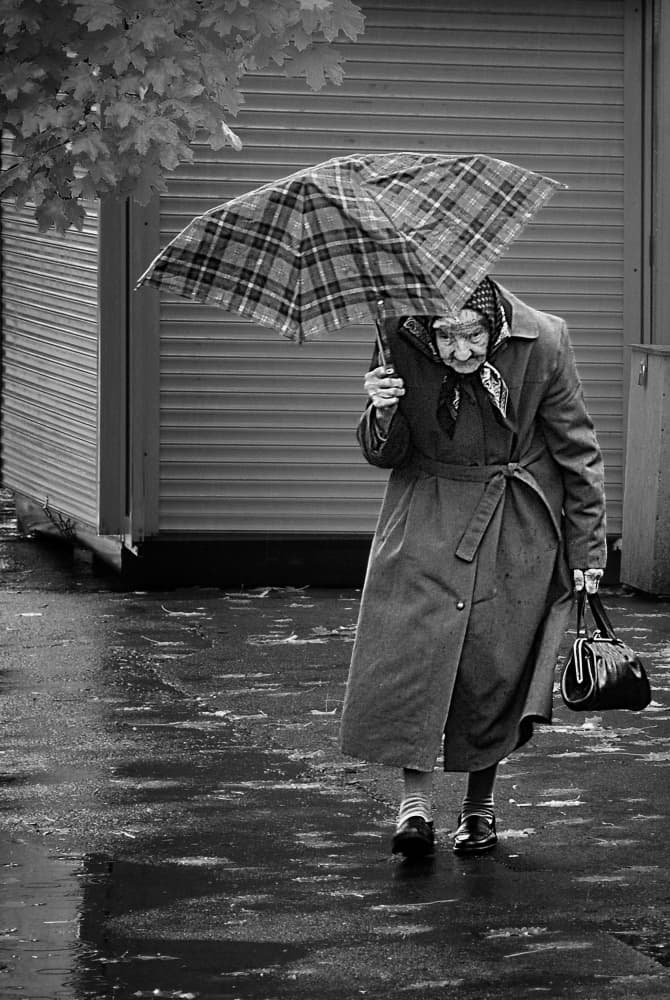 Elderly Woman Rainy Walk by Nicoleta Gabor — canvas wall art