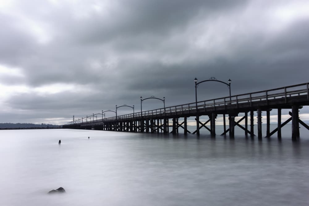 Moody Pier Over Water by Lynann Colligan — canvas wall art