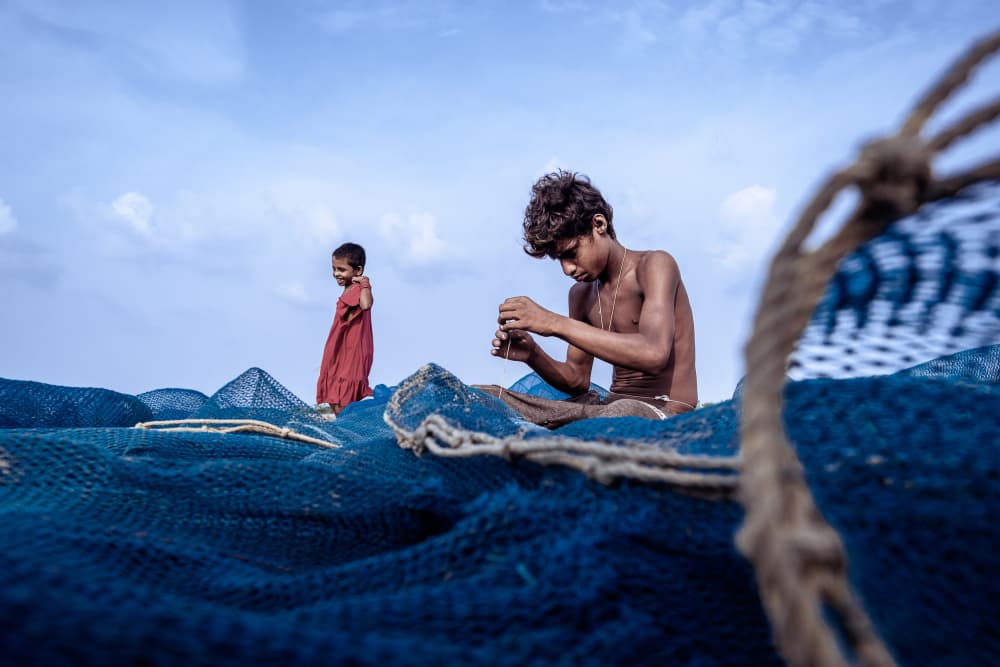 Children Mending Nets by Kuntal Biswas — canvas wall art