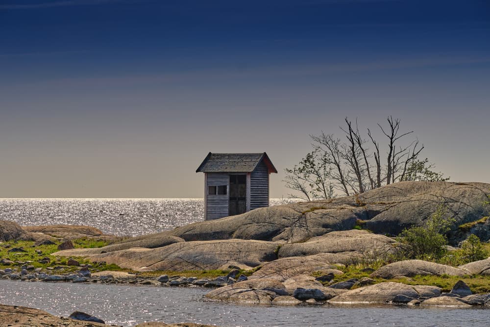 Coastal Shack on Rocks by Geertjan Plooijer — canvas wall art