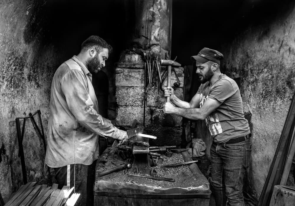 Blacksmiths Forging Metal by Bashar Alsofey — canvas wall art