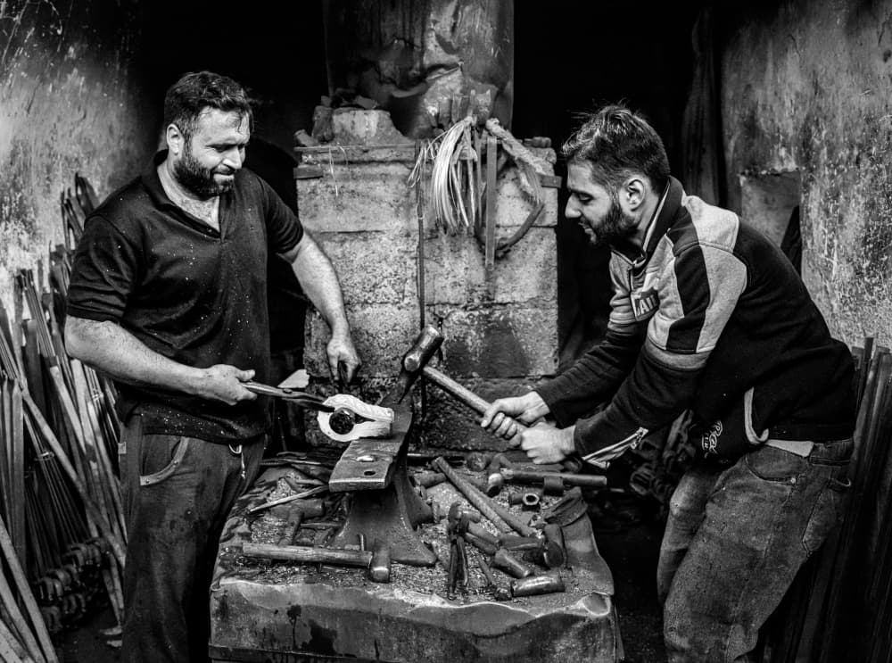 Blacksmiths Forging Metal by Bashar Alsofey — canvas wall art
