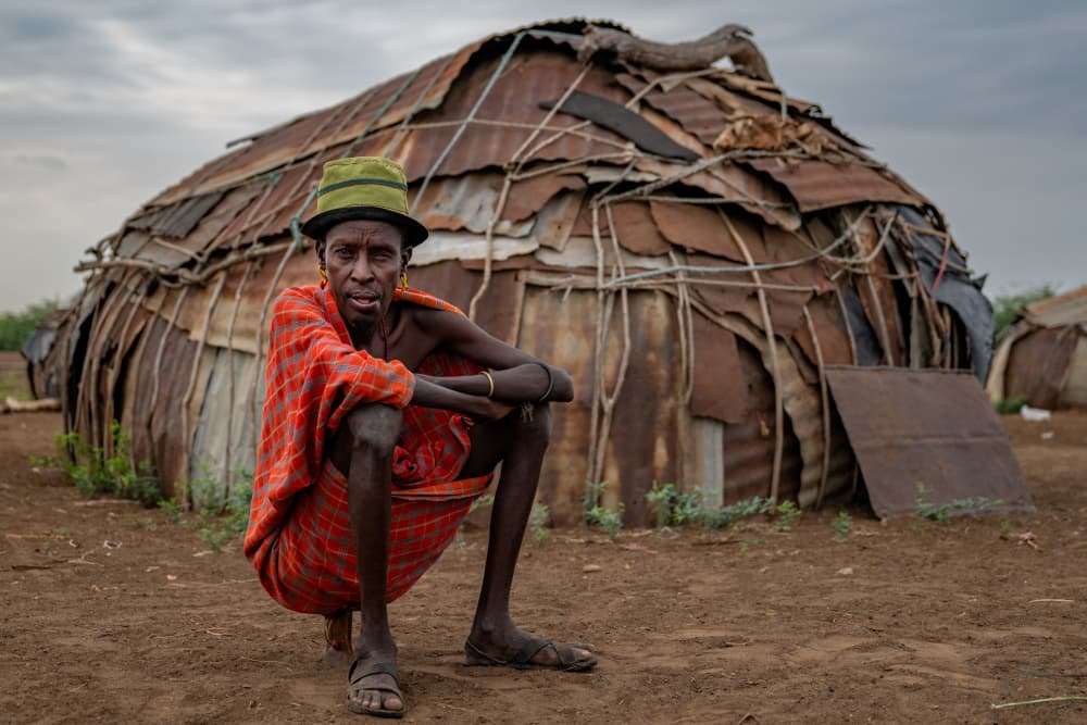 African Elder By Hut by Ilana Lam — canvas wall art