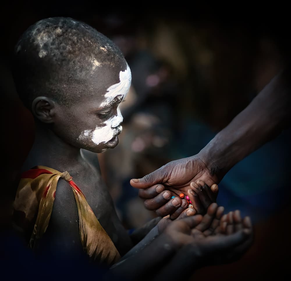African Child Receiving Beads by Juan Luis Duran — canvas wall art
