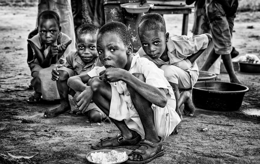 African Boys Mealtime by Joxe Inazio Kuesta Garmendia — canvas wall art