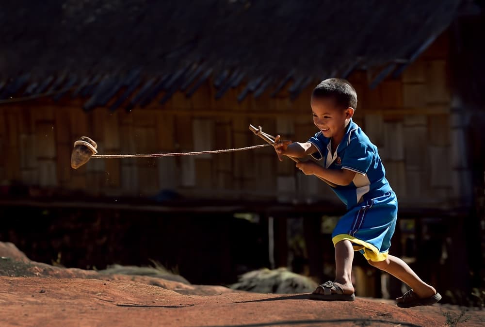 Happy Boy Playing Top by Vichaya — canvas wall art