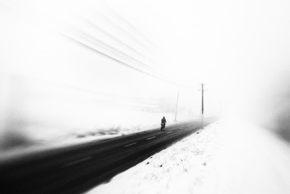 Lone Cyclist Winter Road by Codrin Lupei — canvas wall art