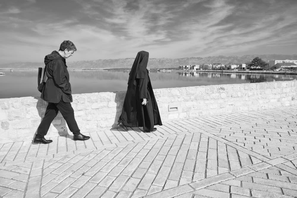 Nun and Woman Seaside Walk by Marko Buntic — canvas wall art