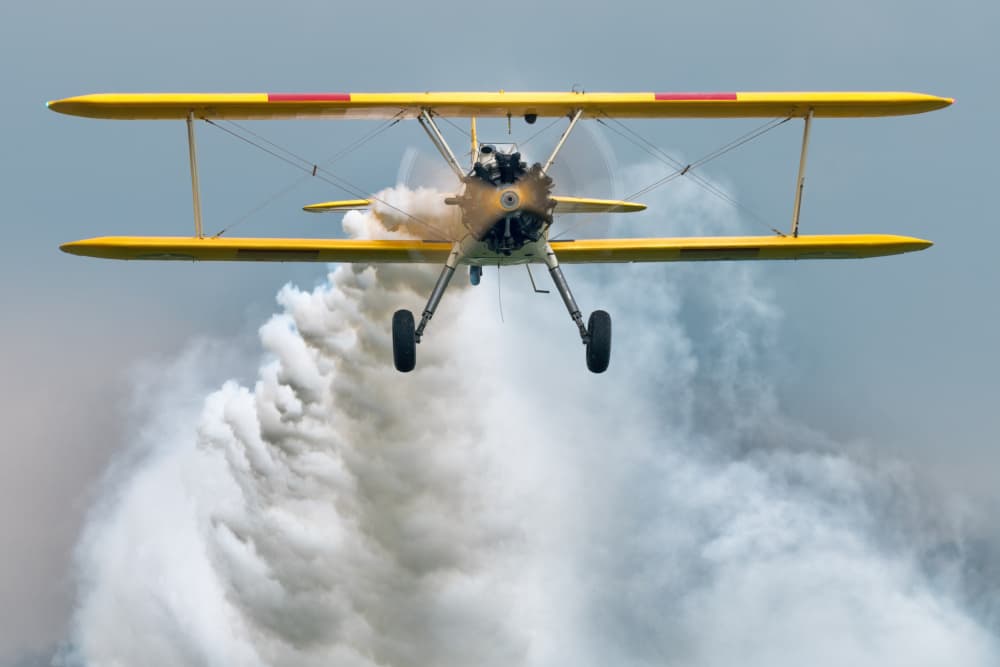 Yellow Biplane Smoke Trail by Piotr Wrobel — canvas wall art