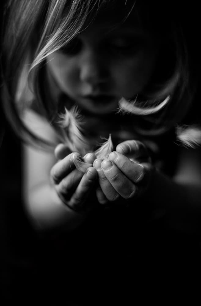 Gentle Child Blowing Feathers by Joe Conroy — canvas wall art