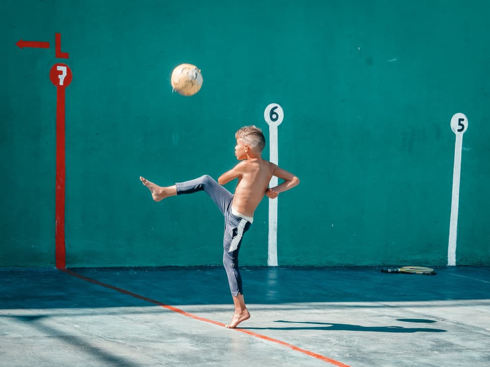 Boy Kicking Soccer Ball by Andy Bauer — canvas wall art
