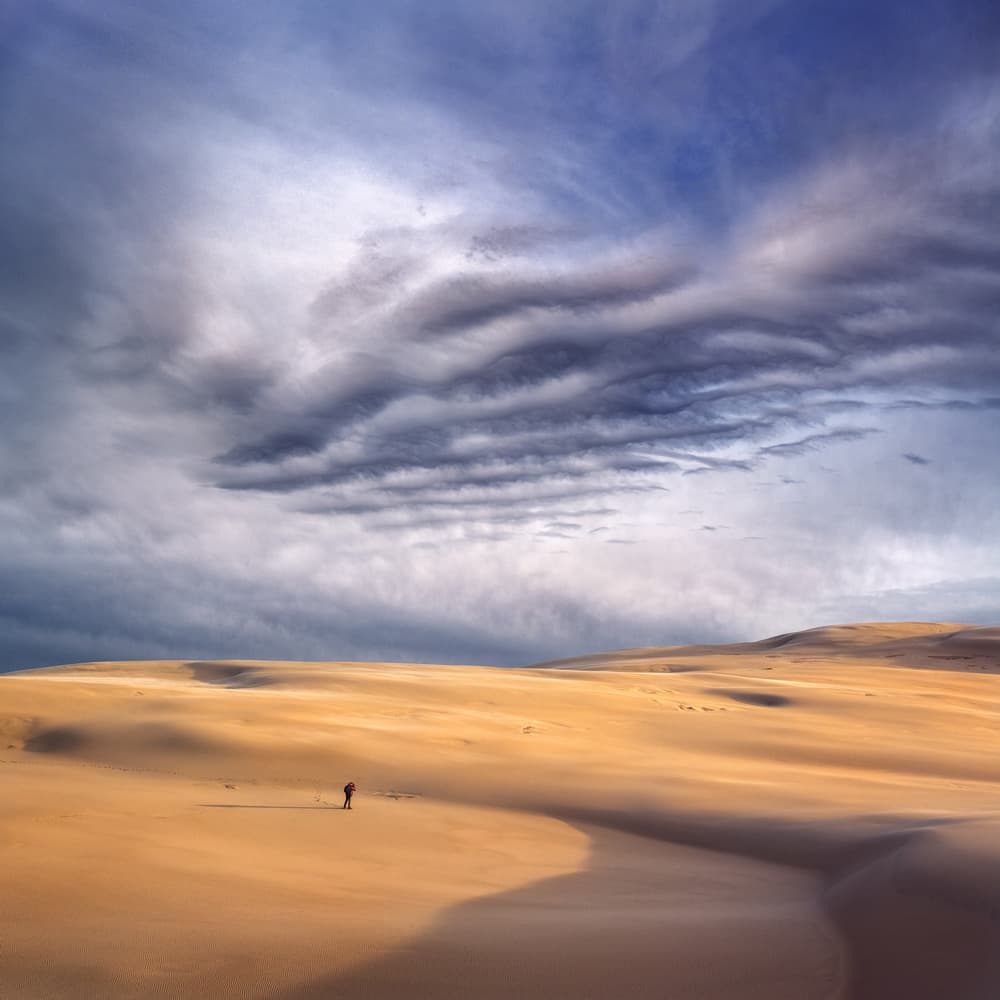 Lone Wanderer Desert Dunes by Grzegorz Lewandowski — canvas wall art
