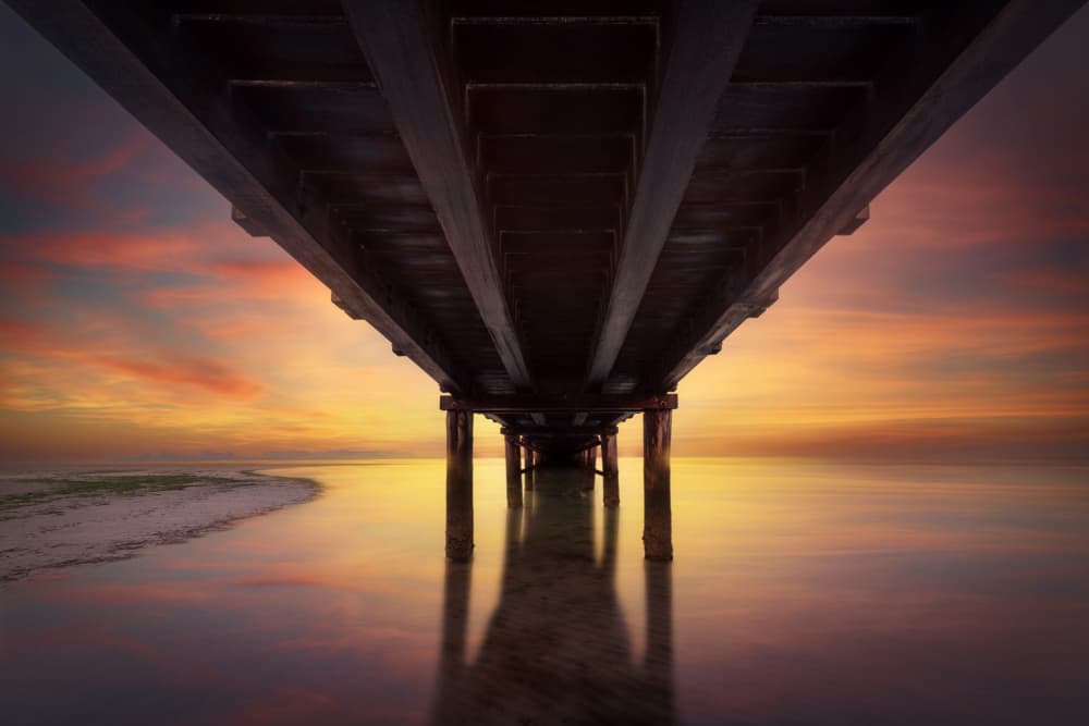 Under The Pier Sunset by Andrea Comari — canvas wall art