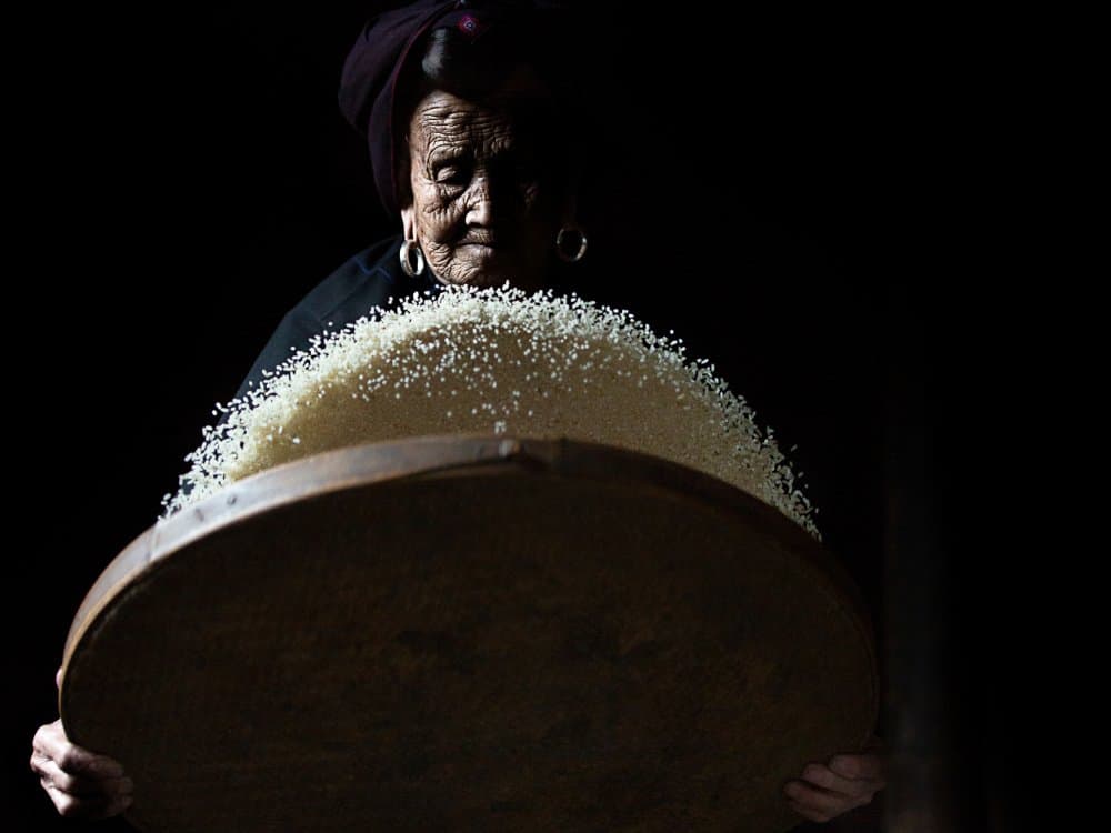 Elderly Woman Sifting Rice by Amnon Eichelberg — canvas wall art
