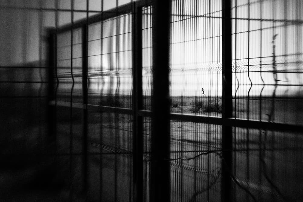 Solitary Figure Beyond Fence by Laura Mexia — canvas wall art