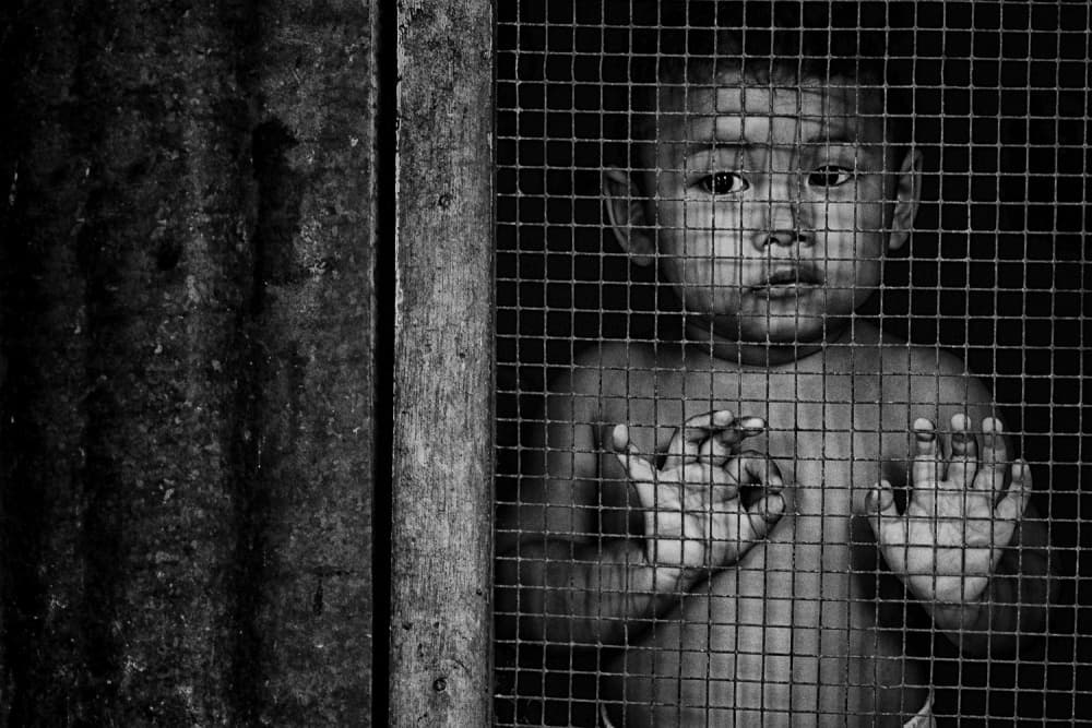 Young Boy Behind Wire by Joey Bangun — canvas wall art