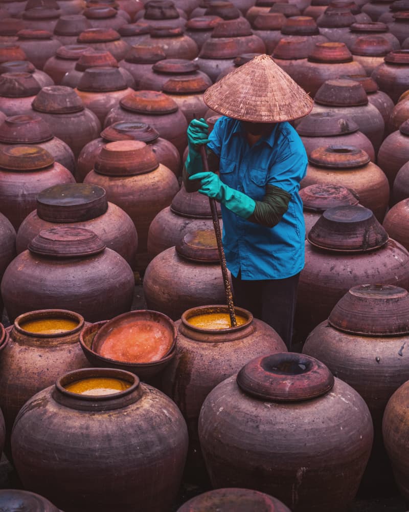 Woman Stirring Clay Pots by Jyoti Prakash Sarmah — canvas wall art