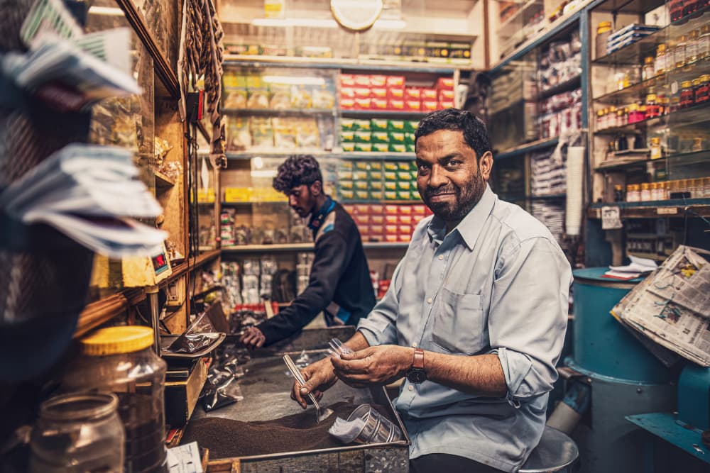 Smiling Indian Shopkeeper by Marco Tagliarino — canvas wall art