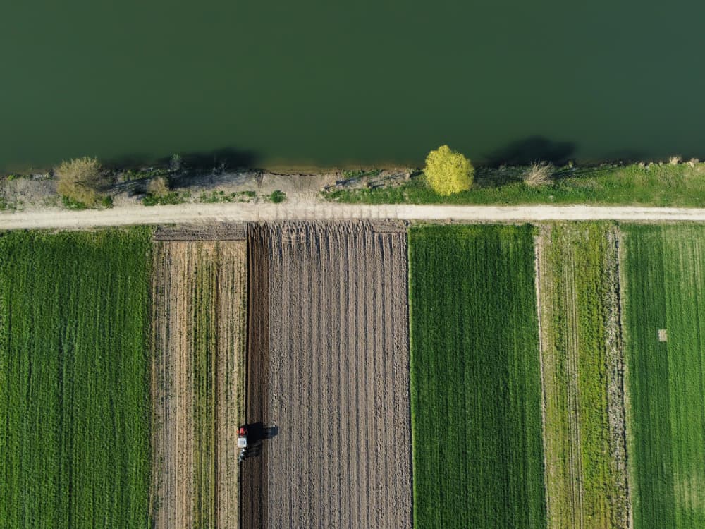 Tractor Plowing River Fields by Primož Kožuh — canvas wall art