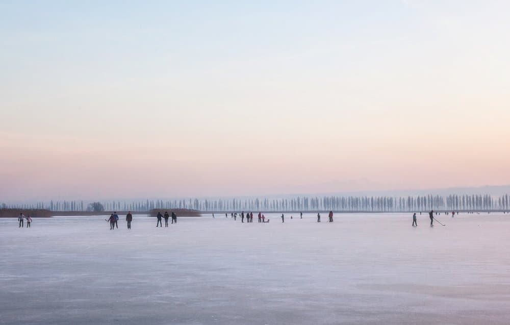 Skaters on Frozen Lake by Uschi Hermann — canvas wall art