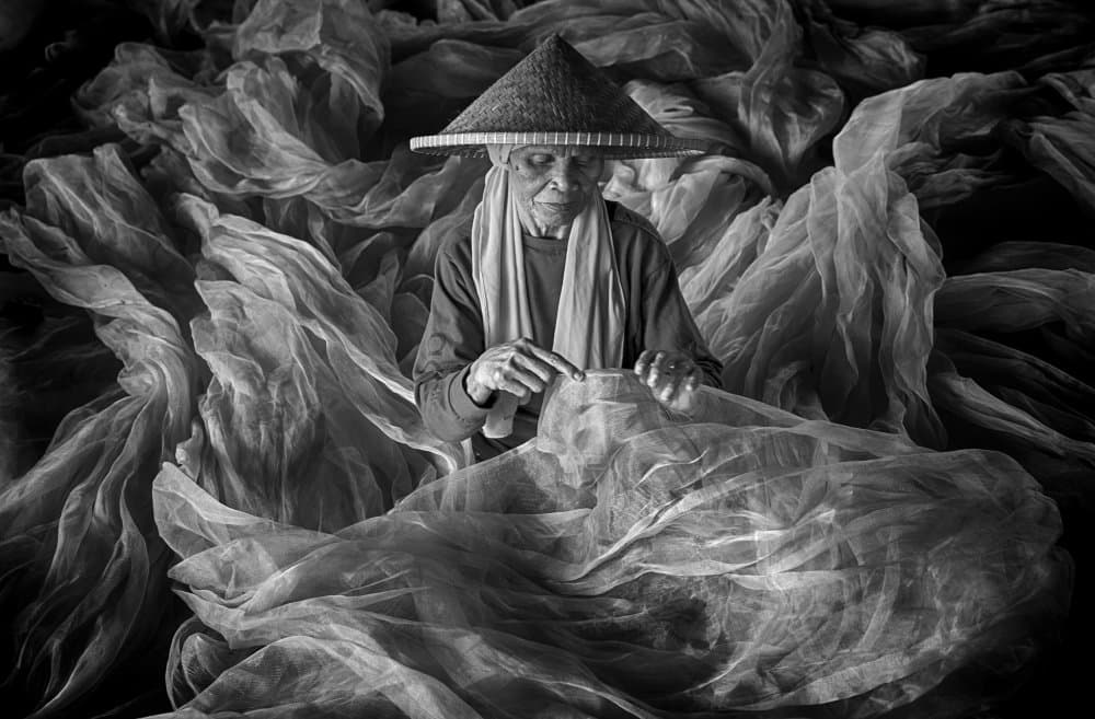 Old Woman Mending Nets by Angela Muliani Hartojo — canvas wall art